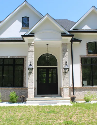 A white and black home with a black door.